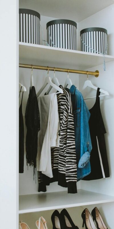 Neatly arranged wardrobe showcasing stylish clothes and shoes indoors.